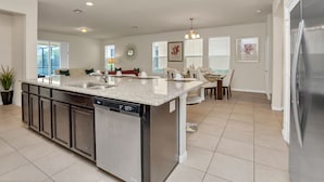 A modern kitchen with a central island, built-in dishwasher, and stainless steel appliances. - 1210yc (Davenport)
