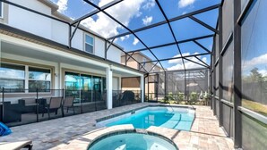 A swimming pool with a glass enclosure, patio furniture, and a view of the surrounding area. - Solara Resort 9 Bedroom 6 Bathroom Resort Villa (Kissimmee)