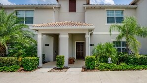 A two-story house with a covered porch, palm trees, and a well-maintained front yard. - 3081juliet (Kissimmee)