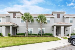 A multi-story residential building with a grey facade, numbered units, and a parking area in front. - 3081juliet (Kissimmee)