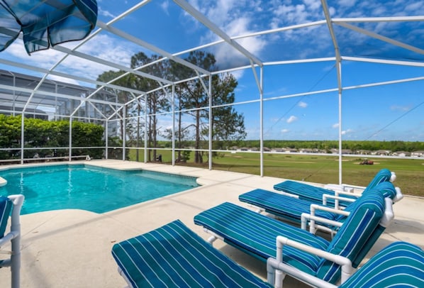 A pool area with lounge chairs and a covered section.