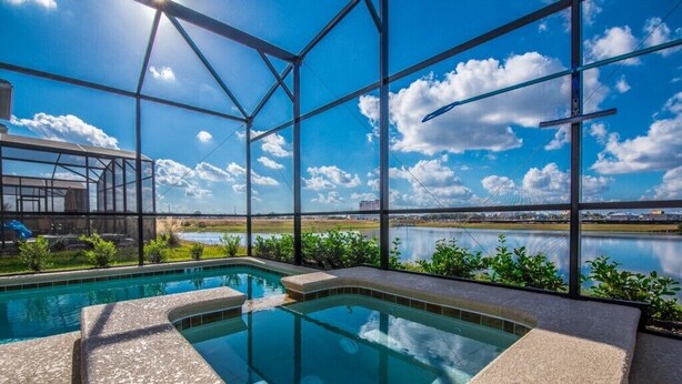 Una piscina con vistas a un lago y un puente al fondo.