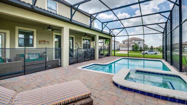 A covered outdoor area with a swimming pool, seating, and a view of the neighborhood. - 1314bw00 (Davenport)