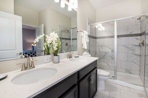 A modern bathroom with two sinks, a large mirror, and a glass-enclosed shower. - 8 Bdrm 5 Bath Villa (Davenport)
