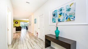 A hallway with a bench, artwork, and a vase. - 9 Bedroom 5 Bathroom Champions Gate Resort (Davenport)