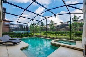 A pool area with a glass enclosure, lounge chairs, and a hot tub.