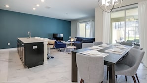 Una cocina moderna con comedor, televisor y sofá.