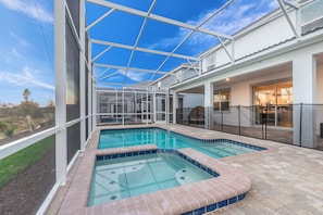 A covered outdoor swimming pool with a glass ceiling, a patio area, and a view of the surrounding landscape. - 8823inter (Davenport)
