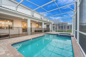 A swimming pool with a glass enclosure, a covered patio area, and a view of a residential building. - 8823inter (Davenport)