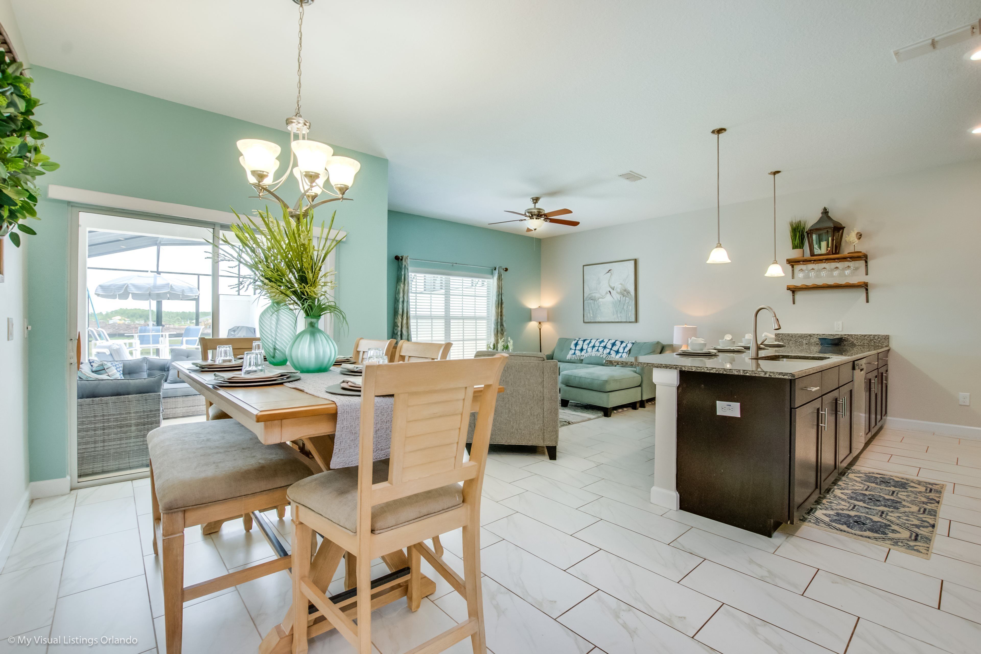 A spacious living area with a dining table, chairs, a sofa, and a kitchen island.