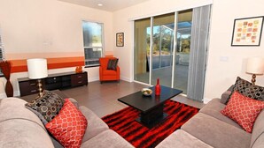 Una sala de estar moderna con un conjunto de sofá, una mesa de centro y un tapete rojo y negro.