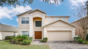 A two-story house with a beige exterior, a front door, and a garage. - 946bd Amazing High End Gated (Davenport)