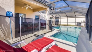 A pool area with lounge chairs and a covered patio. - 946bd Amazing High End Gated (Davenport)
