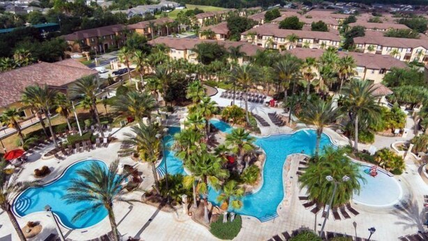 Ein Resort mit mehreren Swimmingpools, umgeben von Palmen und Liegebereichen.