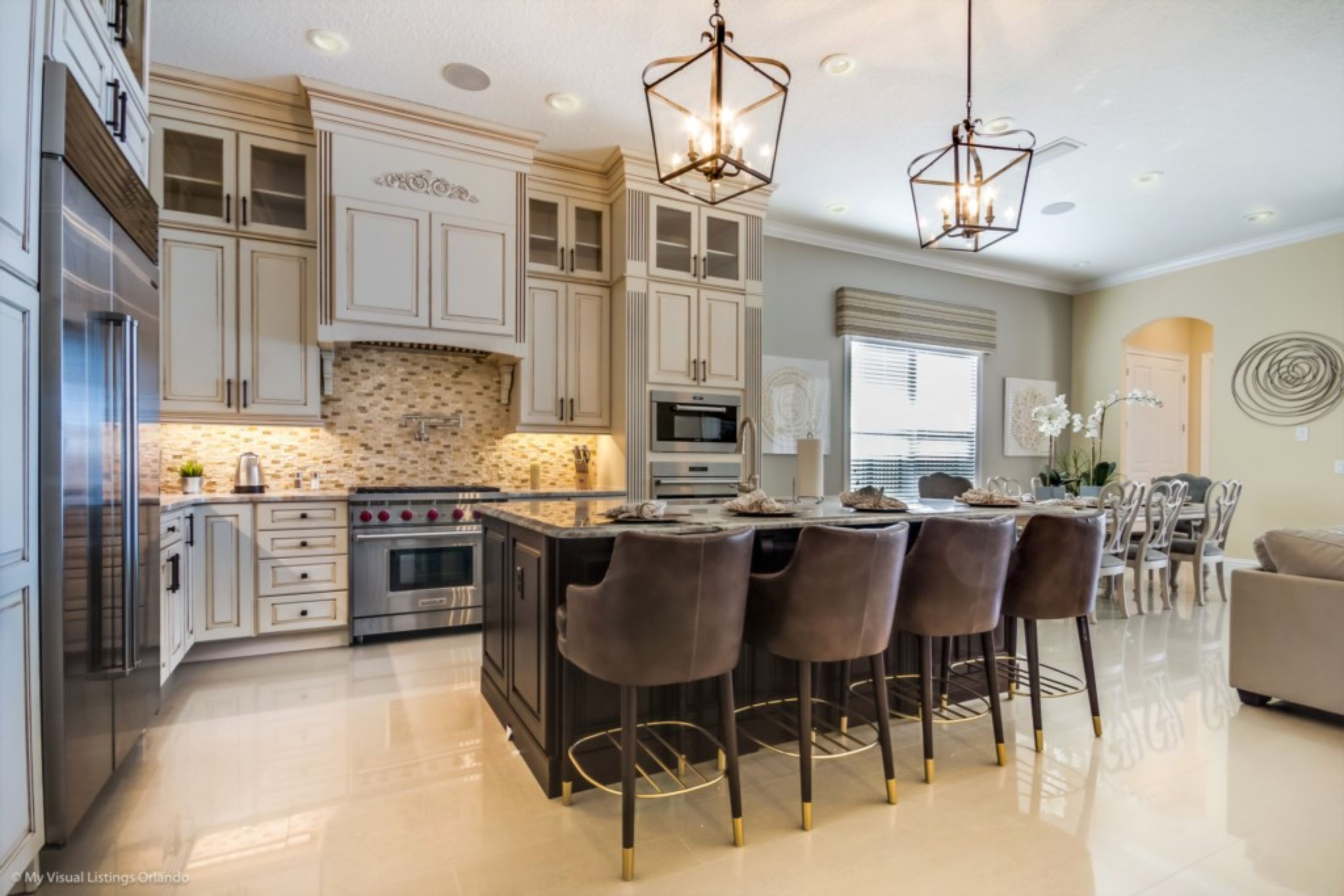 A modern kitchen with a central island, stainless steel appliances, and pendant lighting.