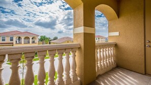 A balcony with a white balustrade overlooking a residential area with houses and a cloudy sky. - 6 Bed 5 Ba Villa with Games & Pool (Davenport)