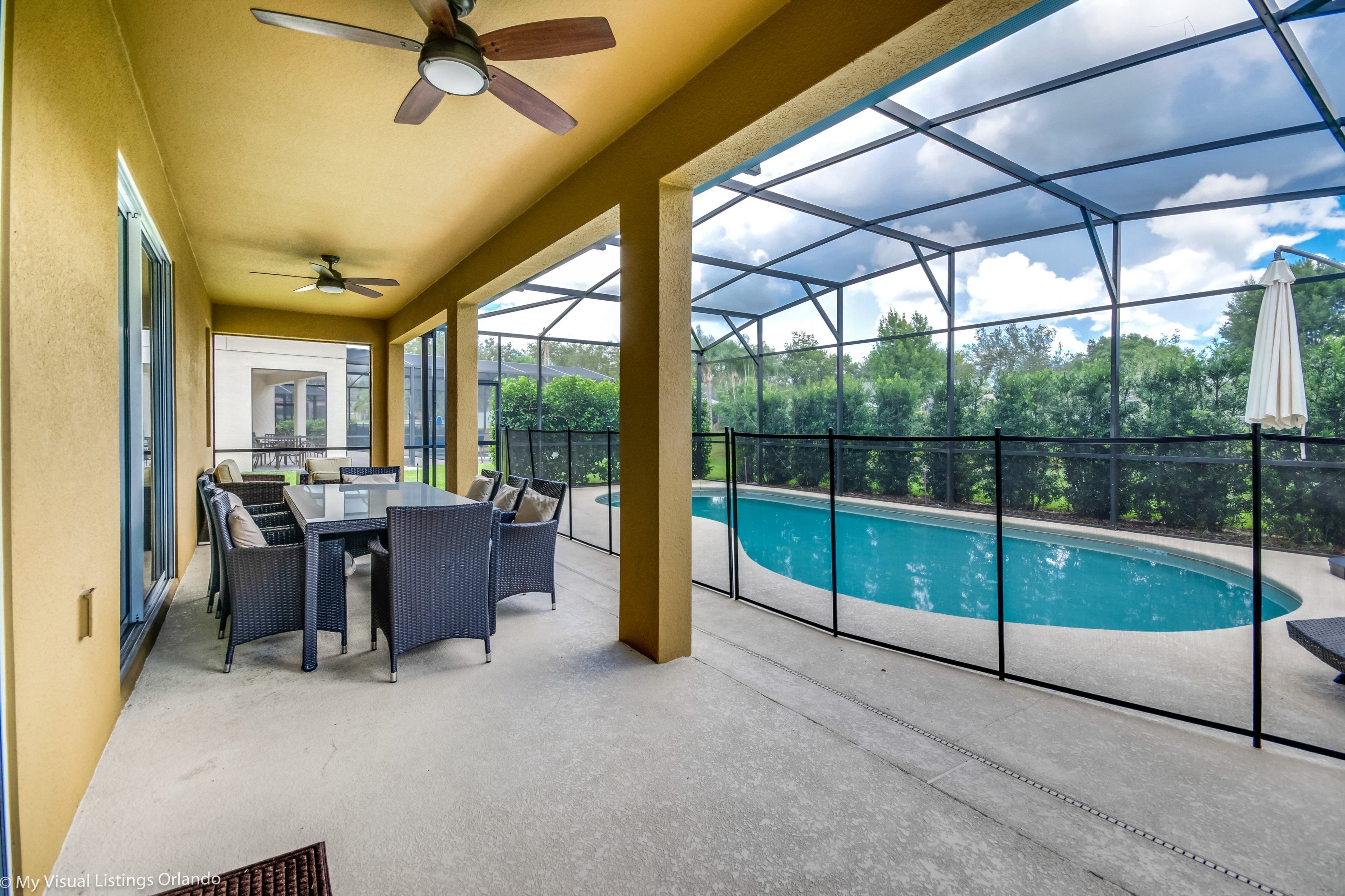 A covered patio with a pool, outdoor furniture, and a ceiling fan.