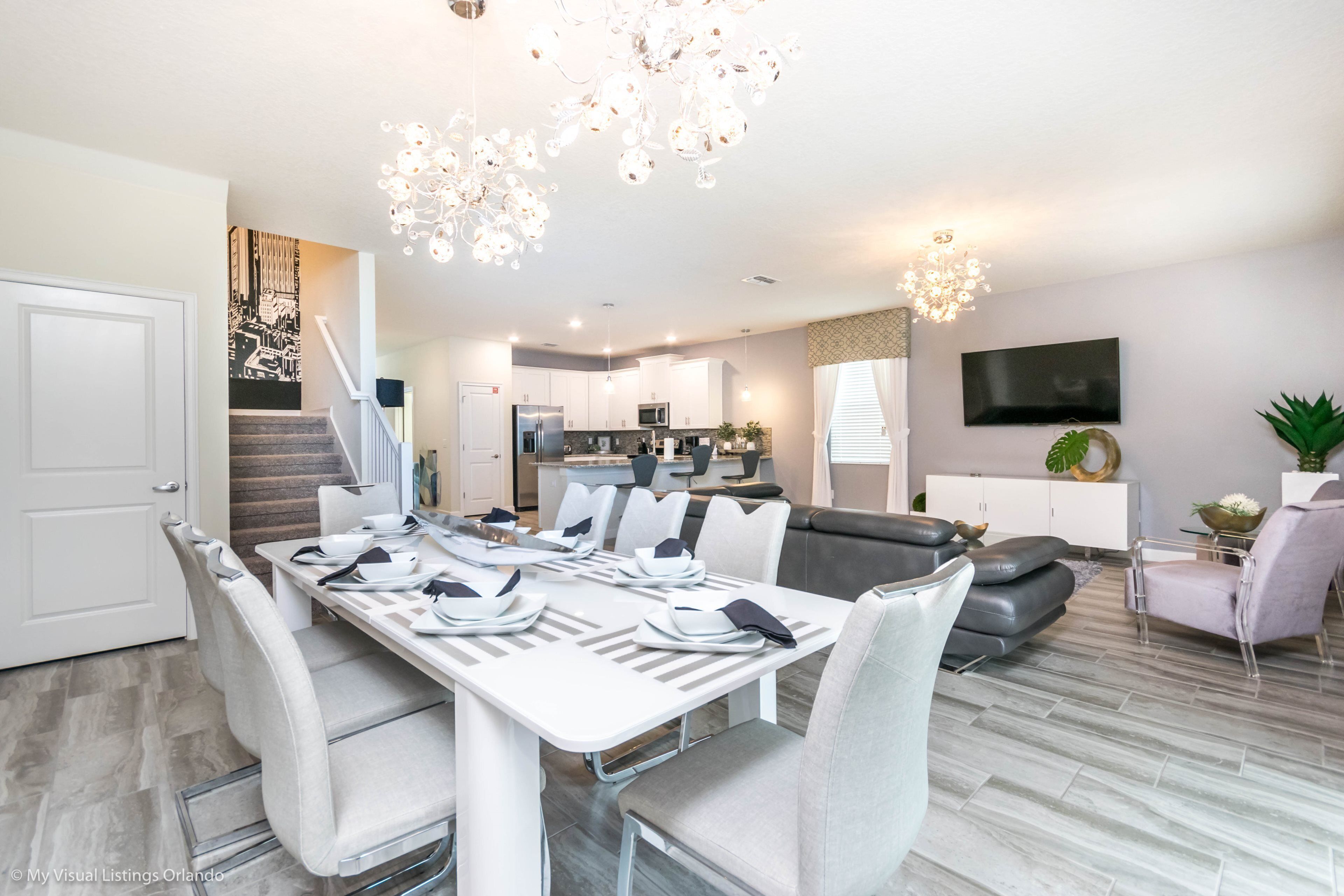 A modern kitchen with white cabinets, a built-in oven, and a microwave.