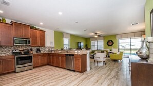 A modern kitchen with wooden cabinets, stainless steel appliances, and a central island. - 1308cw00 (Davenport)
