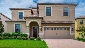 A two-story house with a beige facade, a brown garage door, and a tiled roof. - 1308cw00 (Davenport)