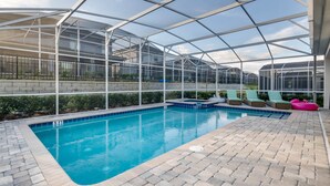 A pool area with a glass-enclosed structure, lounge chairs, and a pool edge.