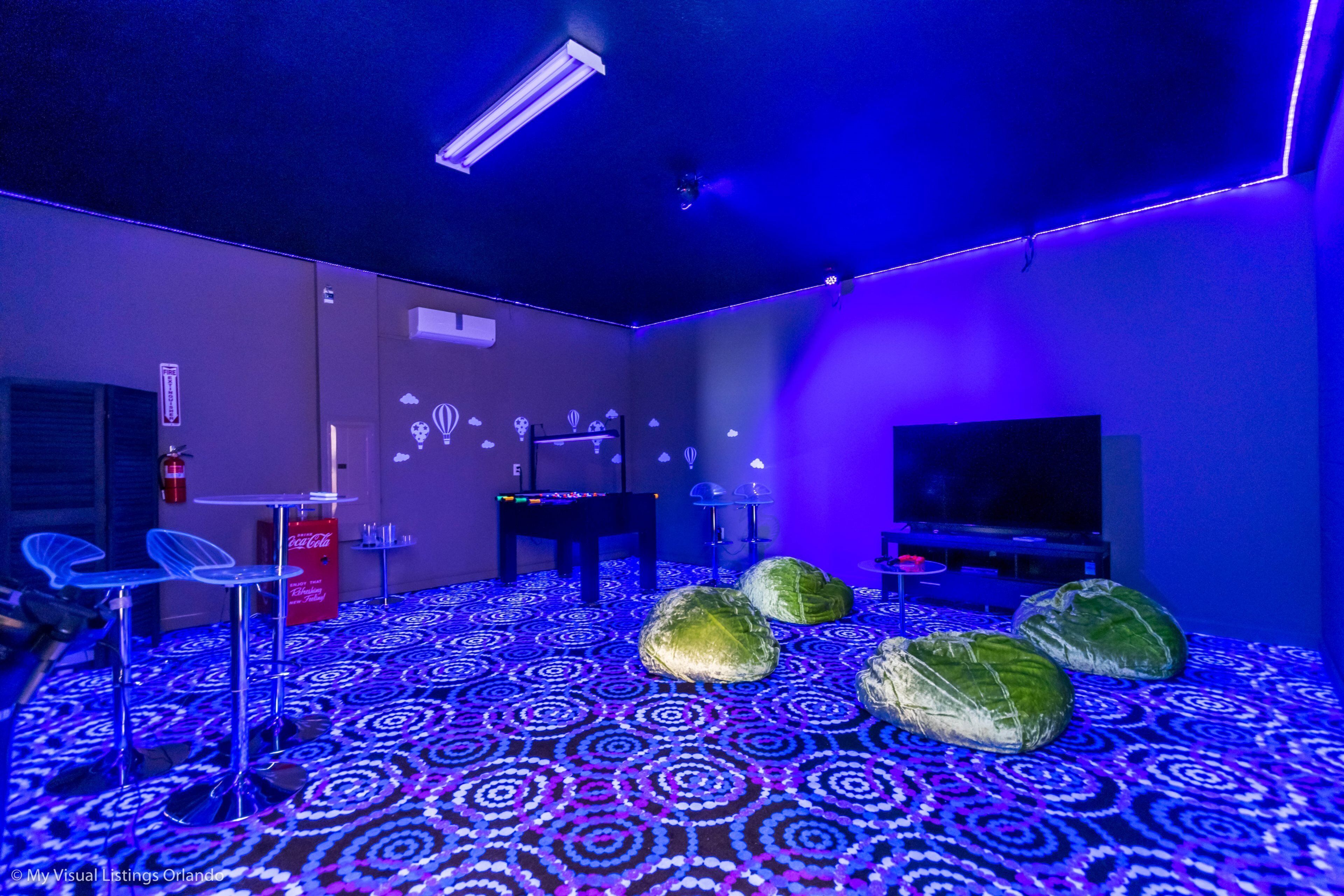 Una habitación con alfombra estampada, televisor y refrigerador Coca-Cola.
