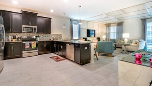 A modern kitchen with dark cabinetry, stainless steel appliances, and a central island.