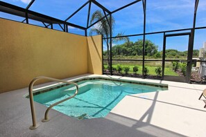 A swimming pool with a clear view of the outdoors through large windows. - Townhome with Pool at Solterra (Davenport)