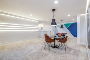 A modern dining area with a round table, four chairs, and pendant lighting. - 14 Bdrm 11 Bath Villa For 30 (Davenport)