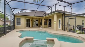 A swimming pool with a glass enclosure, a hot tub, and a covered patio area. - Fantastically Decorated 4 bed 3 Bath (Davenport)