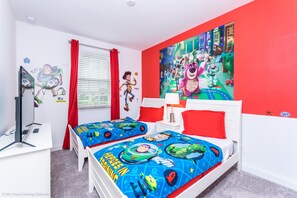 A bedroom with two beds, red and white bedding, a TV, and a large wall mural.