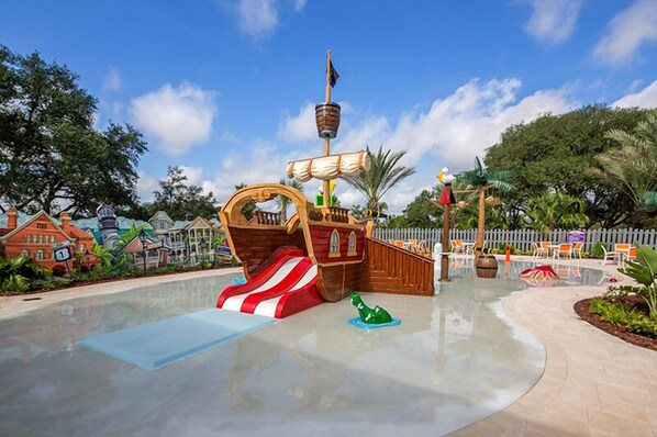 A pirate-themed play area with a slide, a ship-shaped play structure, and a small green sea creature figure.