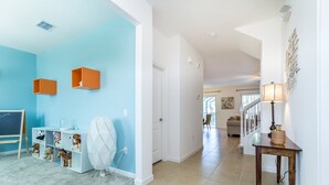 A spacious living area with a light blue wall, a white console table, and a wooden side table with a lamp. - Classic 6Bed 4Ba Villa, Games, Pool, Spa - 5244o (Davenport)