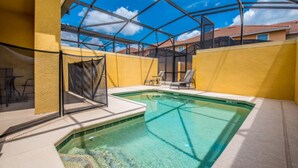 An indoor swimming pool with clear water, surrounded by yellow walls and a glass enclosure. - 4 Bedroom 3 Bathroom Town Home With Pool (Kissimmee)