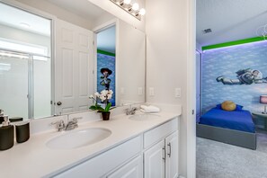A modern bathroom with a double sink, a large mirror, and a potted orchid. - 1834cvt New Solara 9 Bedroom 6 Bathroom Resort (Kissimmee)
