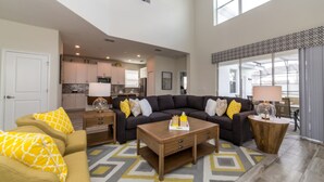 A spacious living area with a large sectional sofa, a coffee table, and a patterned rug.