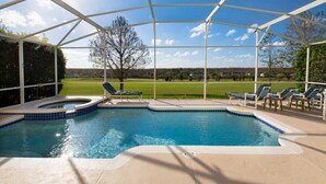 A covered swimming pool with lounge chairs and a view of a green landscape. - 353 Glen (Davenport)