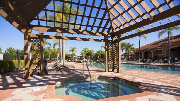 A pool area with a pergola structure, lounge chairs, and a clear view of the pool. - Bella Vida 4570 IHR 1020 (Kissimmee)