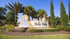 A sign with "Bella Vida" written on it, surrounded by palm trees and a decorative fountain. - Bella Vida 4570 IHR 1020 (Kissimmee)