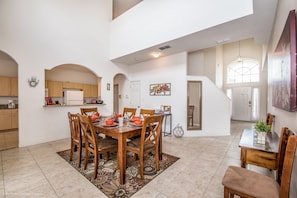 A spacious dining area with a high ceiling and a view of the kitchen. - 4701rrl (Kissimmee)