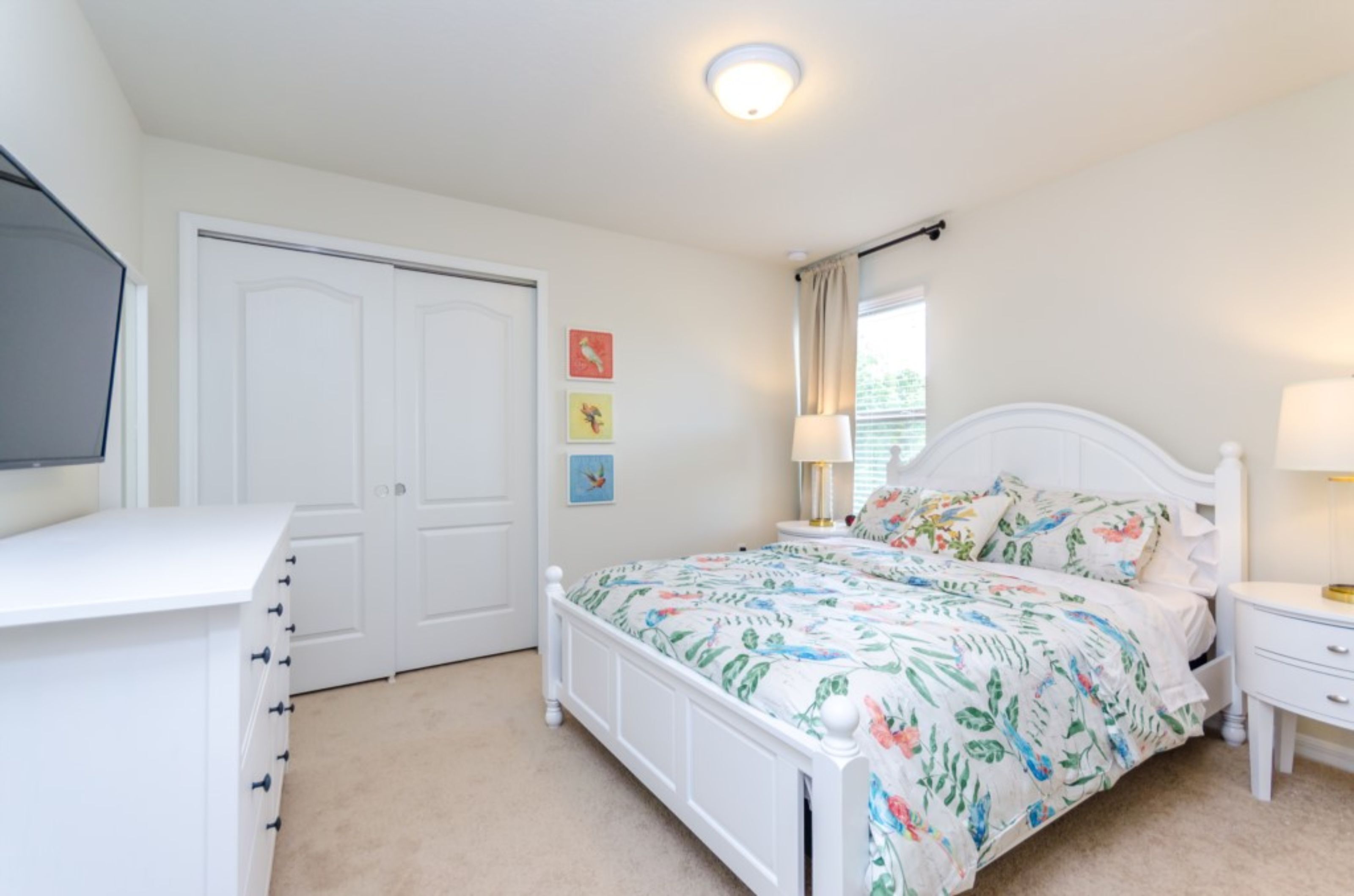 A bedroom with a bed, bedside table, lamp, and a wardrobe.