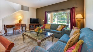 A spacious living room with a large sofa, a coffee table, and a television. - 2735calab (Davenport)