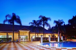 A hotel with a pool, palm trees, and a checkered floor. - 3036skd (Kissimmee)