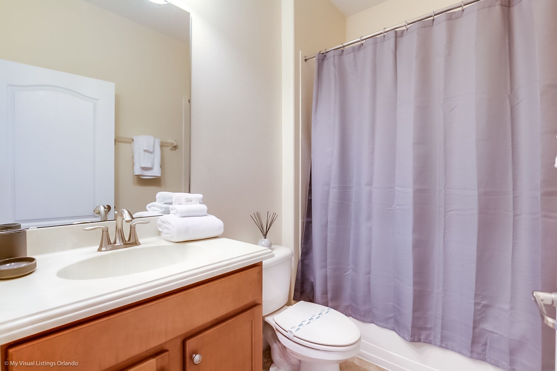 A bathroom with a white sink, a toilet, and a shower curtain.