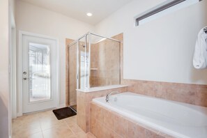 A modern bathroom with a glass-enclosed shower, a large bathtub, and a white door. - 1804gobi Amazing 7 Bedroom 5 Bathroom Windsor (Kissimmee)