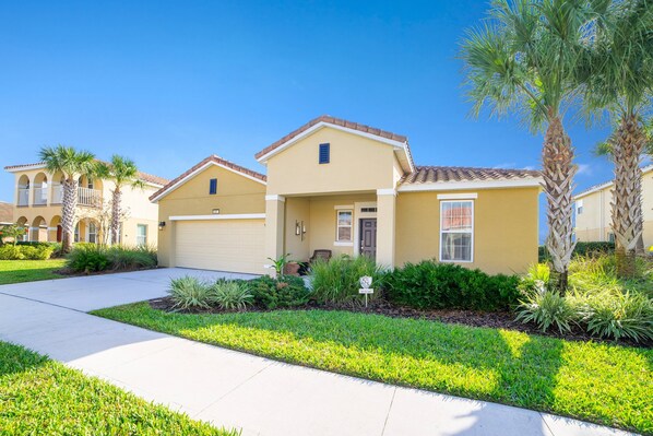 A residential building with a garage, a front porch, and a well-maintained lawn. - 5 Bedroom 5 Bathroom Solterra Resort Luxury Villa (Davenport)