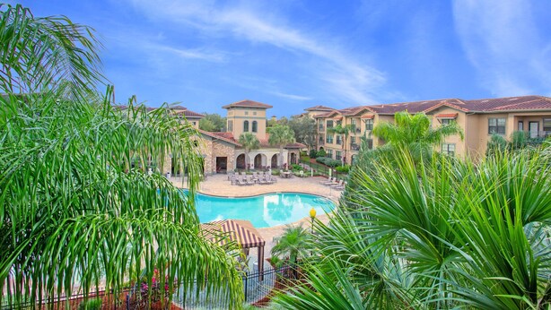 A resort with a swimming pool, lounge chairs, and palm trees. - 3 Bed 3 Bath Pool View High End Corner Condo (Davenport)