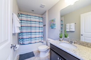 A bathroom with a shower curtain, toilet, sink, and a mirror. - Family Friendly 5Bed 4Ba Villa, Games, Pool, Spa - 5200w (Davenport)