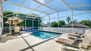 A covered swimming pool area with lounge chairs and a table, surrounded by a white canopy. - 215glen Amazing Newly Decorated 5 Bedroom (Davenport)