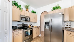A modern kitchen with stainless steel appliances, light wood cabinets, and a marble floor. - 215glen Amazing Newly Decorated 5 Bedroom (Davenport)